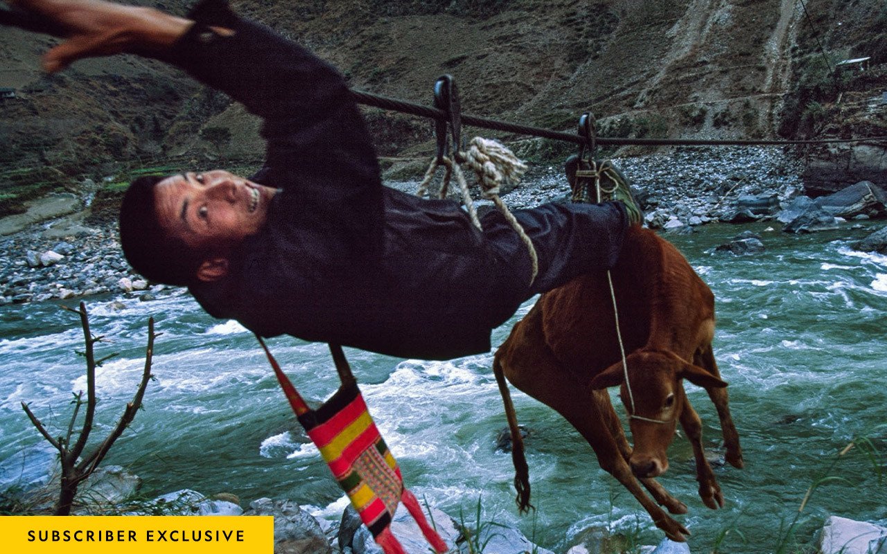 Nan Boyi hauls his cow to market along a zip line suspended above the Nu River in China.