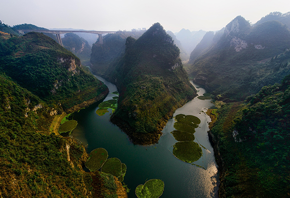 The gorges of Guizhou Province glimmer in the sunlight in China. Fossil teeth found in this province suggest that thousands of years ago, a cave here was home to a mysterious branch of the human family tree.