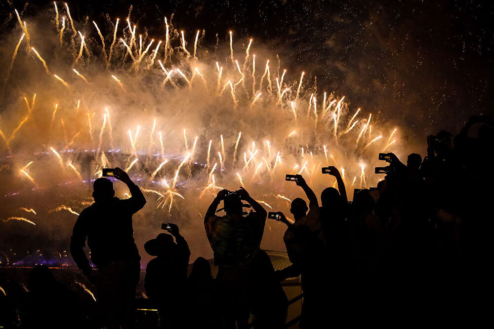 A picture of people photographing a fireworks display