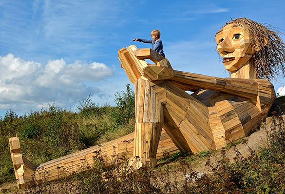 One of artist Thomas Dambo’s recycled wood troll sculptures sits on a hilltop in the Trine neighborhood of Copenhagen. Dambo creates them to encourage people to explore nature and to highlight environmental issues.