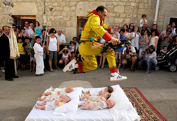 A man representing the devil leaps over babies during the festival of El Colacho in Castrillo de Murcia, Spain.