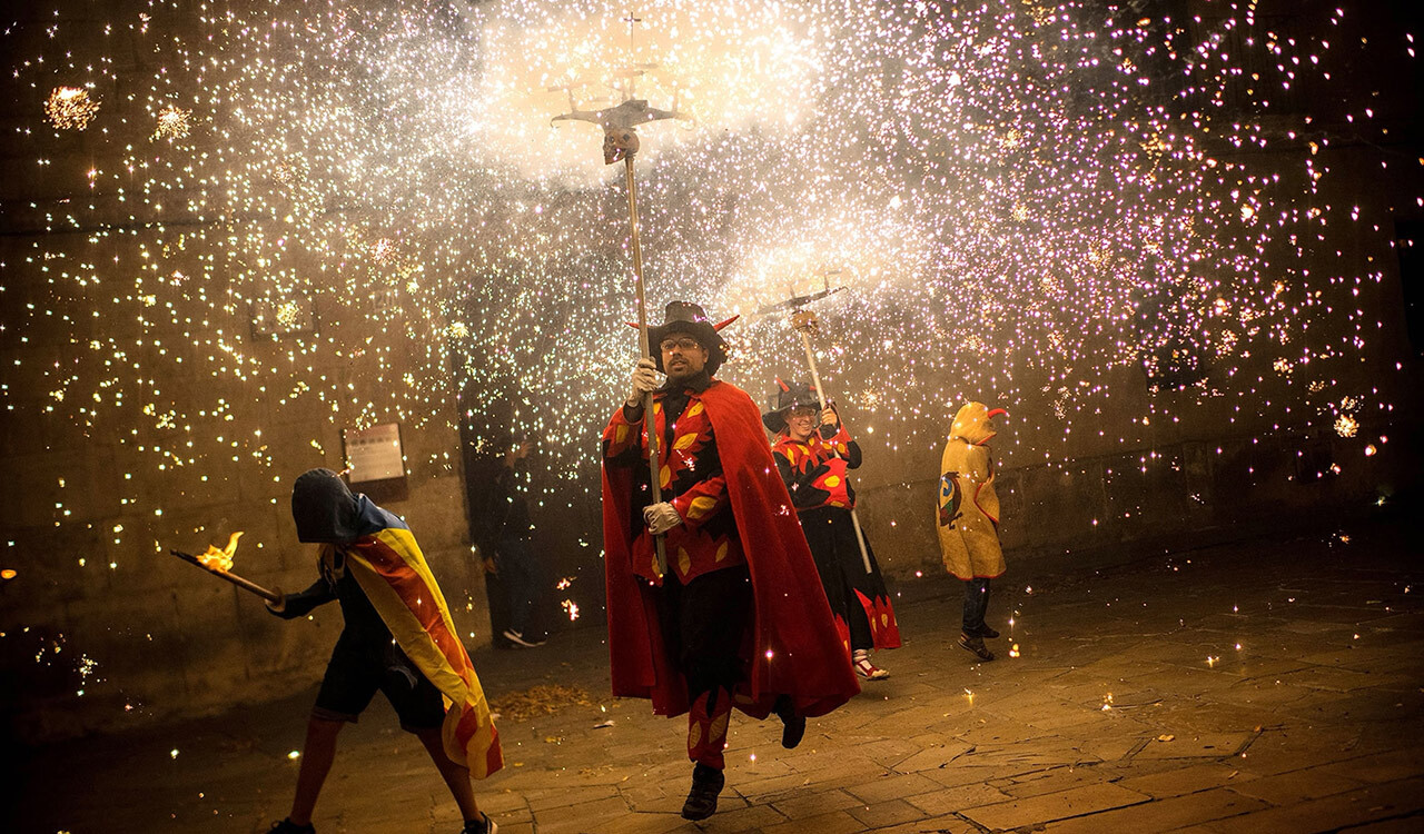 Traditional correfoc, or "fire-run," performers dress as devils and light fireworks from pitchforks during a during a Catalan pro-independence demonstration in September, 2017.