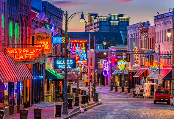 The flourescent signs of historic Beale Street shine at twilight.