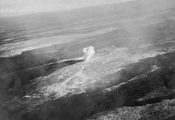 An aerial view shows a bomb detonating on Mauna Loa during a 1935 eruption. The U.S. Army dropped 20 600-pound bombs on the lava flow that December morning to divert the molten rock from reaching the town of Hilo.