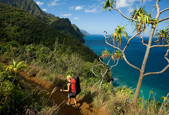 A hiker explores the Kalalau Trail on the Na Pali Coast of Kauai, Hawaii.