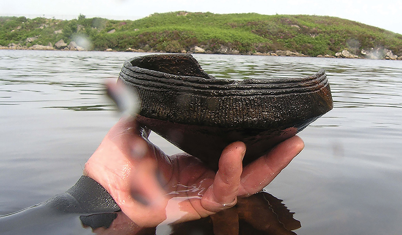 A diver holds a Neolithic (ca. 3,500 B.C) Ustan vessel found near a crannog (artificial island) in Loch Arnish, Scotland.