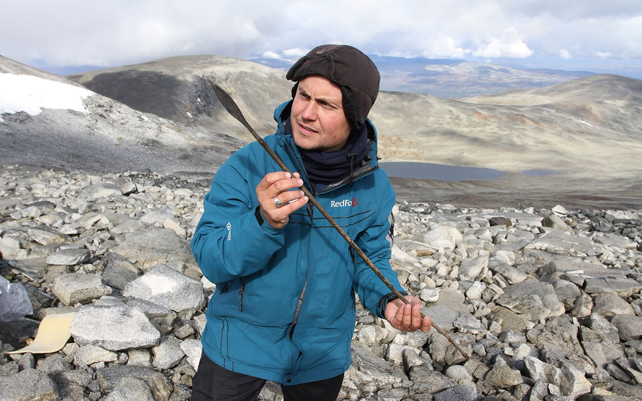 Archaeologist holding a c. 1400-year-old arrow, lost reindeer hunting in the high mountains of Oppland, Norway, during the Late Antique Little Ice Age.