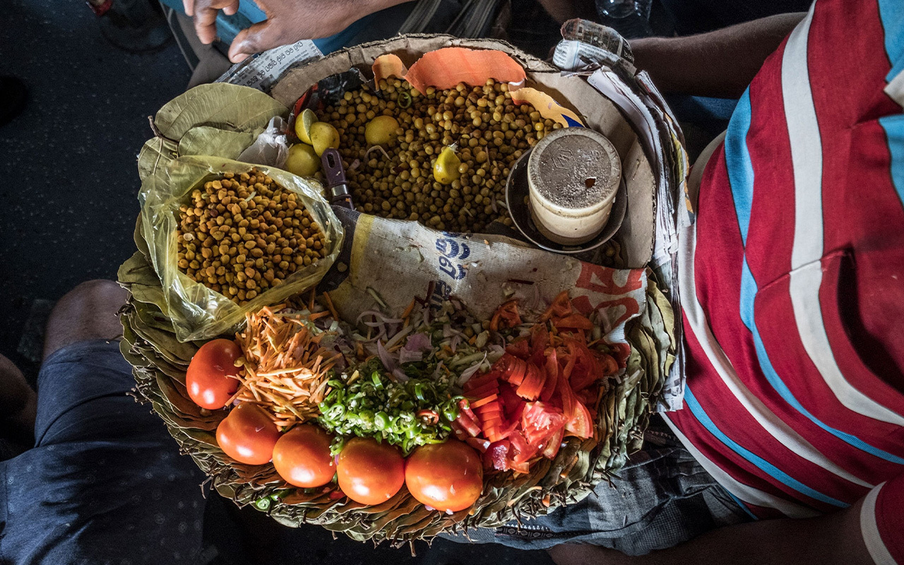 A vendor prepares a snack for sale on the longest train ride in India, between Kanyakumari and Dibrugarh city.