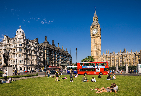 Londoners lounge near the Palace of Westminster's Big Ben.