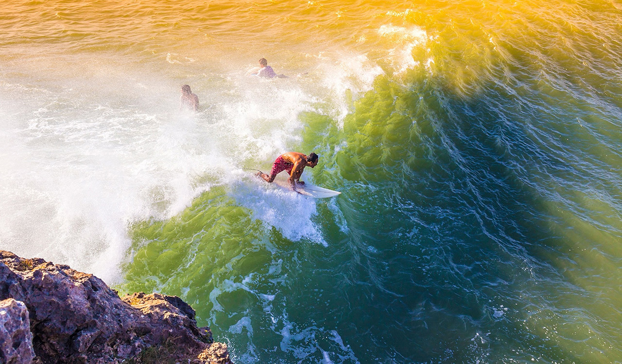A surfer rides a wave in Bali, Indonesia.
