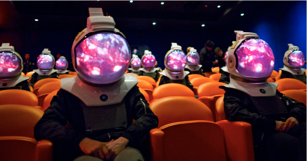 People with multicolored helmets sit in an auditorium