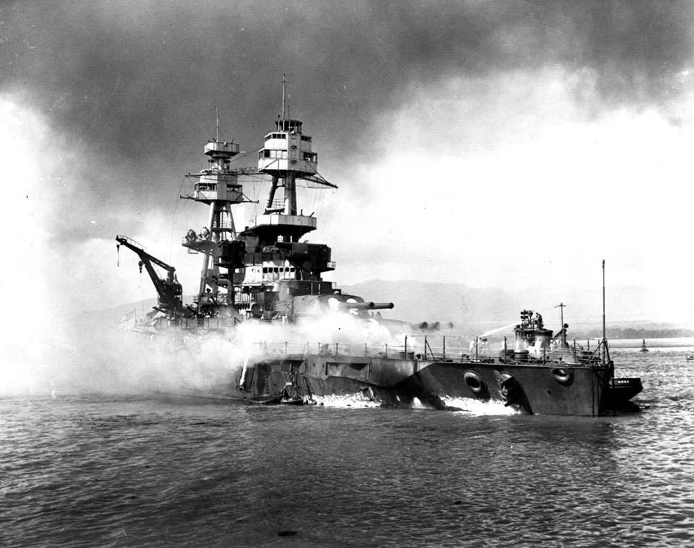 USS Nevada (BB-36) beached and burning after being hit forward by Japanese bombs and torpedoes at Pearl Harbor in 1941.