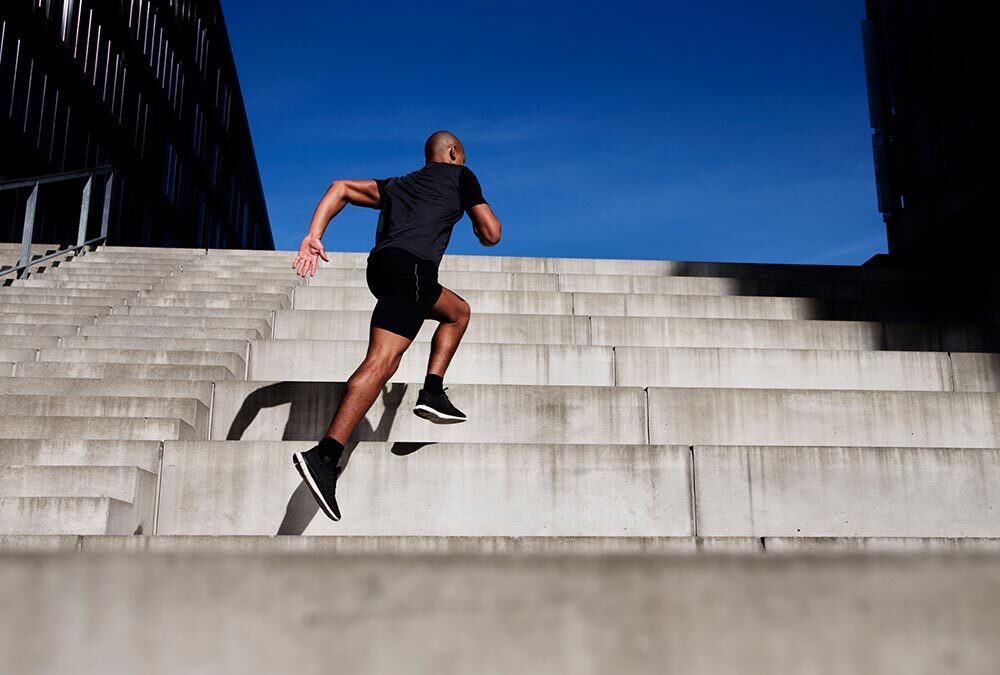A man runs up stairs outdoors