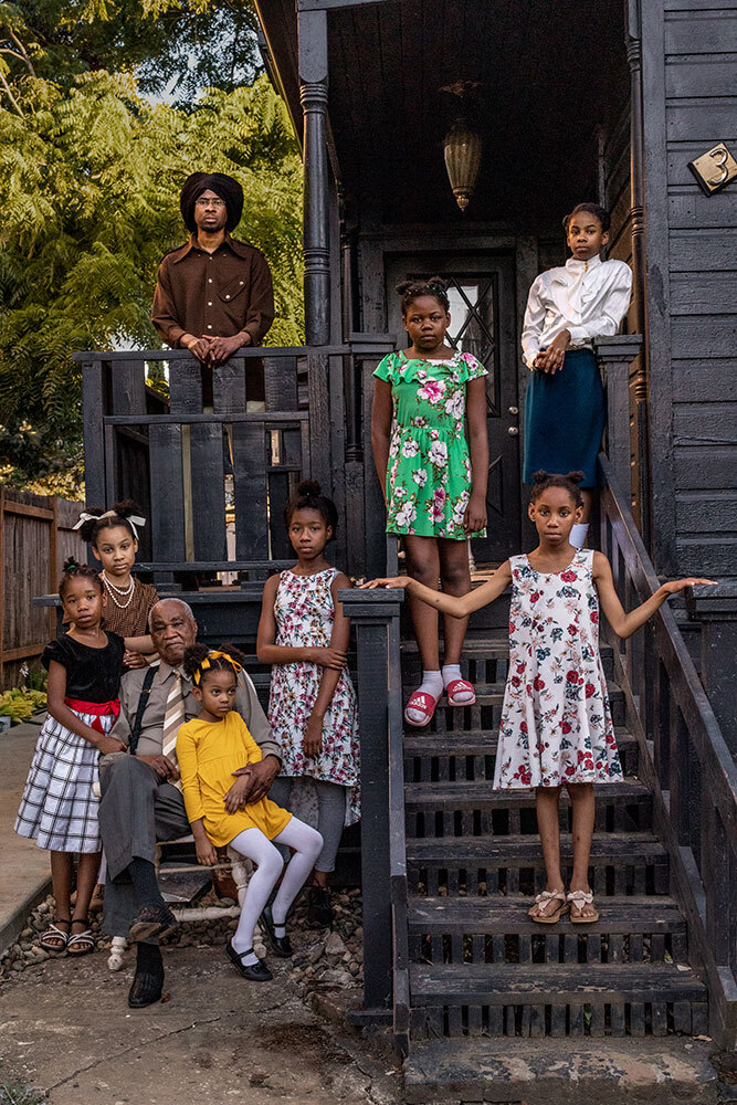 Cleo Davis, Sr., sits in front of his son, Cleo Davis, Jr., and surrounded by his grandchildren outside their home in Portland. In the 1980s, the Davis family purchased an investment property near North Williams Avenue, once known as the Black Broadway. Before they could repair and rent it out, the city of Portland deemed it blight and bulldozed it.