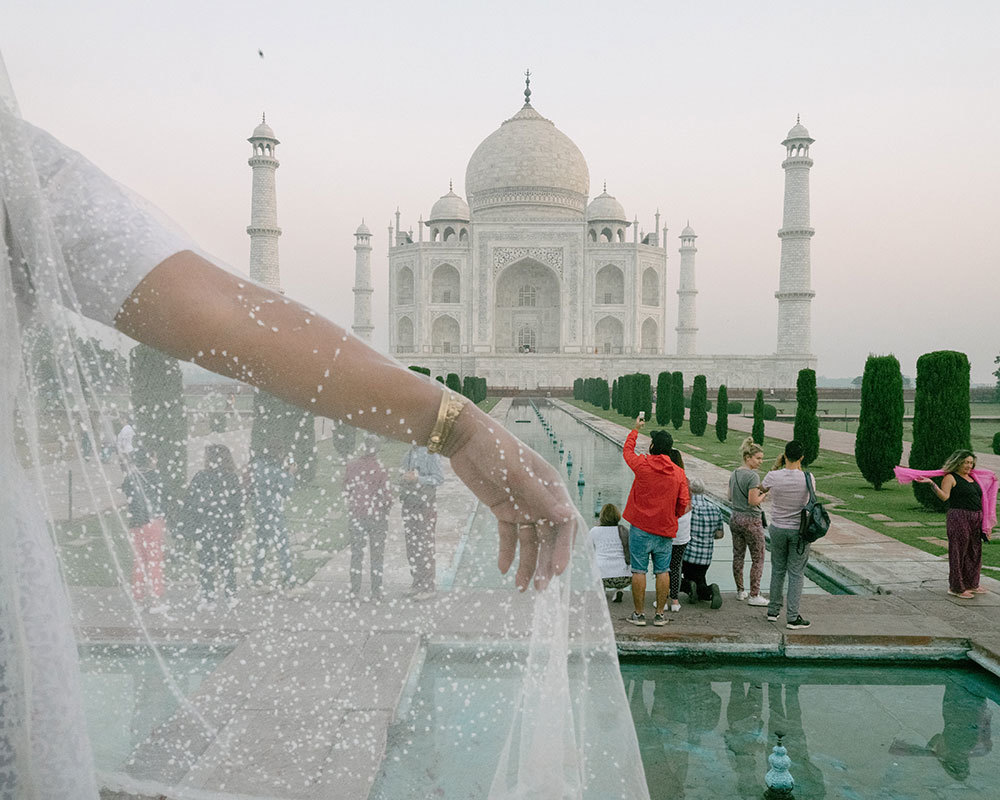 A picture of the Taj Mahal partially obscured by a woman