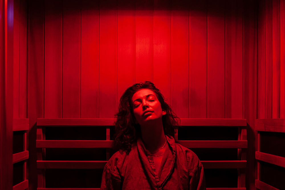 A woman sits in an infrared sauna—which uses light to create heat instead of electric heaters or steam—in New York City