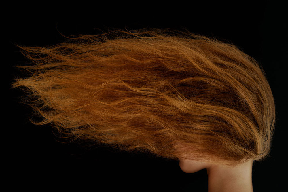 A picture of a red hair blown across a person's face