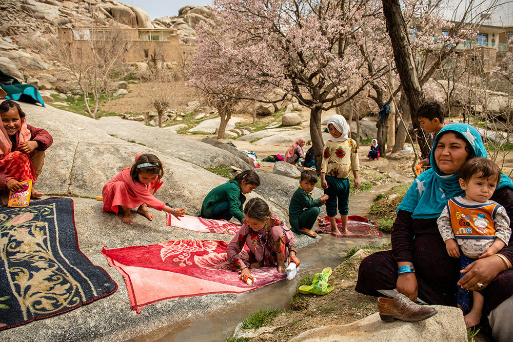 Afghan women and children clean and wash clothes