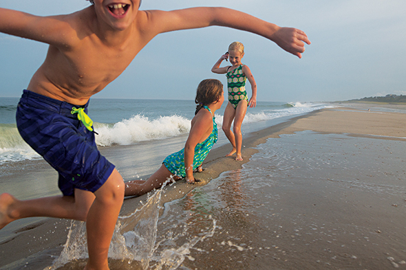 A local family romps in the surf at Nauset Spit in Orleans, Massachusetts.