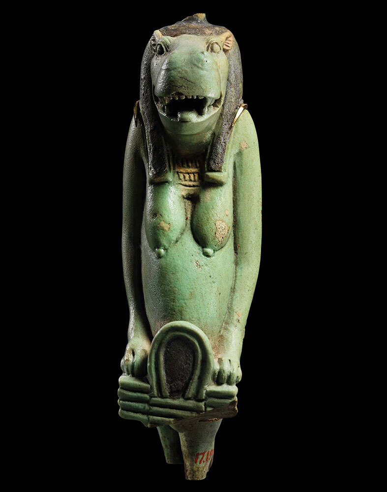 A green amulet of hippo goddess Taweret, circa 664-332 B.C., on a black background.