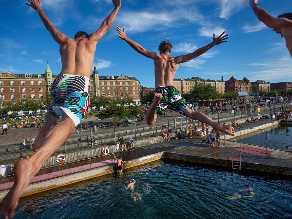 A photo of three guys jumping into a pool of water