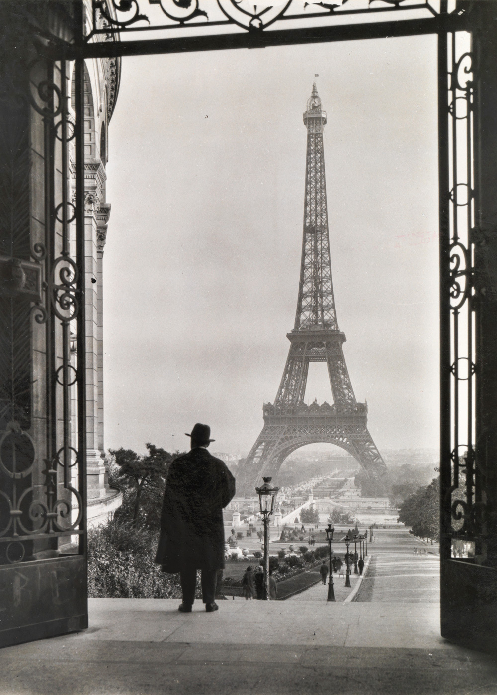 A 1929 photo of a man by the Eiffel Tower in Paris.