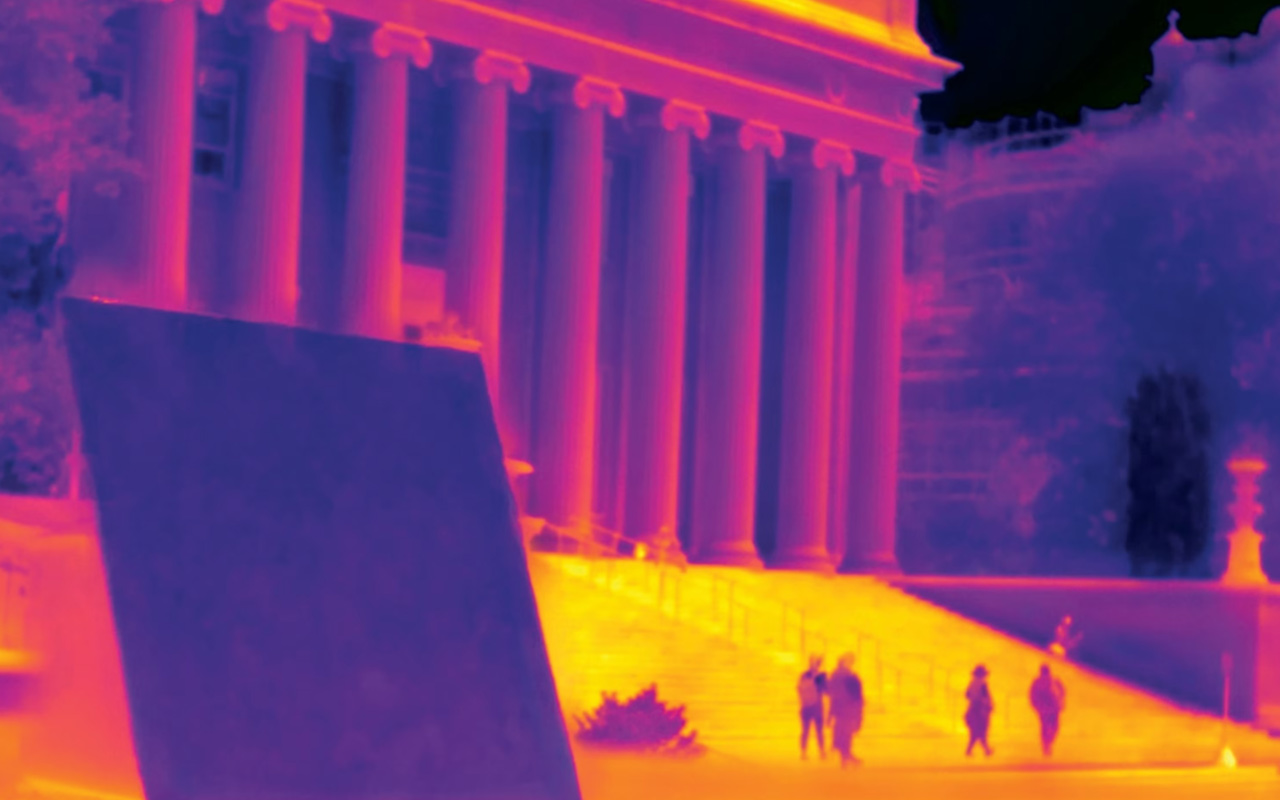 An infrared map image showing a cool blue panel and the yellow and orange hot sidewalks with a red and orange medium hot building in the background.