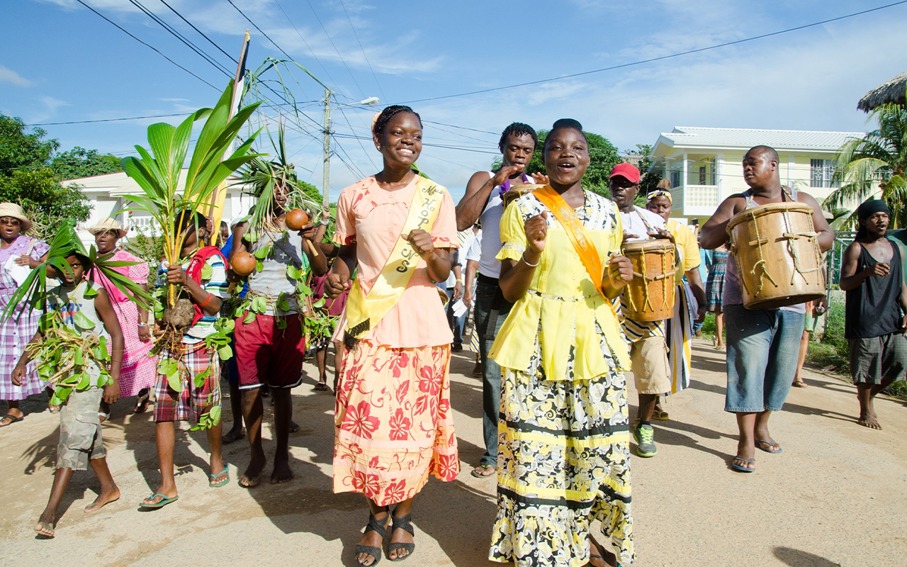 A procession of singers, dancers, and drummers make their way along the main road in the village of Hopkins in the Stann Creek District of Belize.