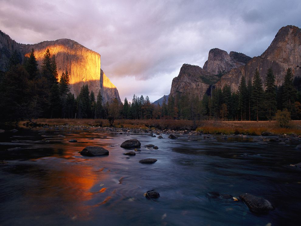 River flowing in front of rock formations in California's Yosemite Valley