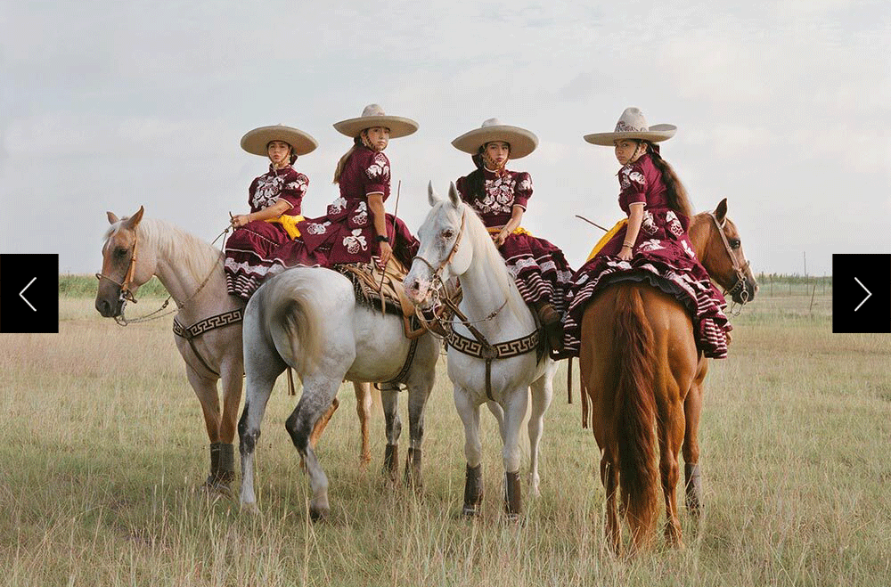 Four young women on horseback dressed in the same dresses and hats looking into camera.