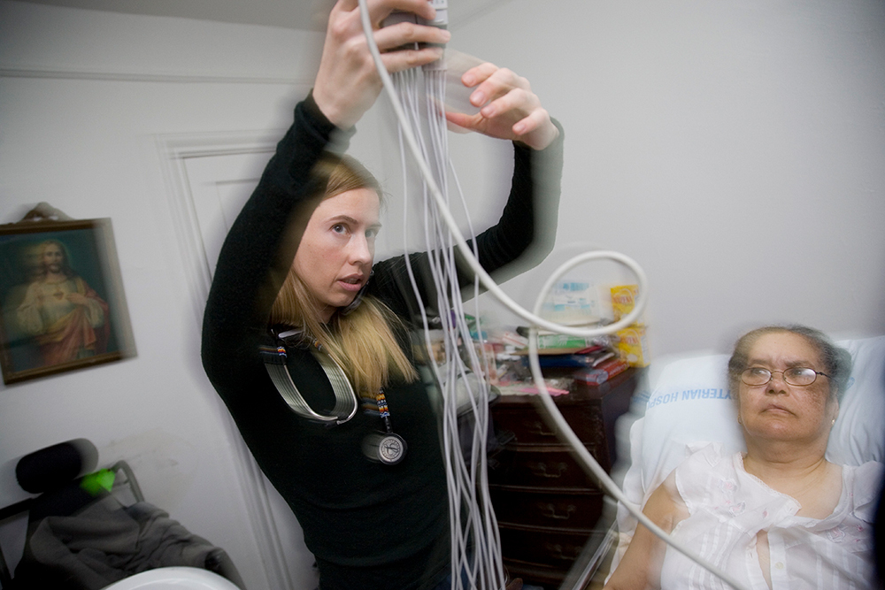 Ana Blohm administers an electrocardiogram to Alfrida Corniel in her home in New York City. Corniel suffers from a rare disease called stiff person syndrome, which left her with muscle stiffness similar to being paralyzed. Scientists are still unraveling what causes this disorder.