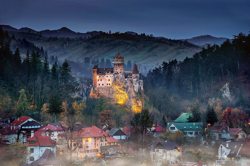 A castle overlooks a foggy town