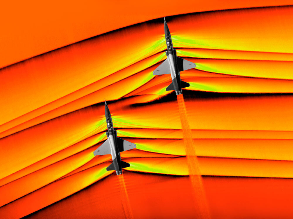 the interaction of shock waves—heard as sonic booms—produced by two U.S. aircrafts traveling approximately 30 feet apart at supersonic speeds