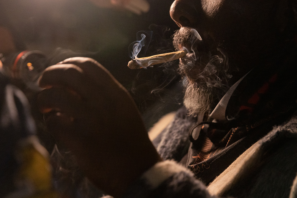 A close up of a bearded man smoking a joint