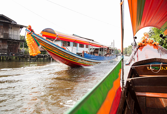 Colorful boats float along the Chao Phraya River in Bangkok. Some of Bangkok's unique communities and traditions are at risk of disappearing to make room for large developments.