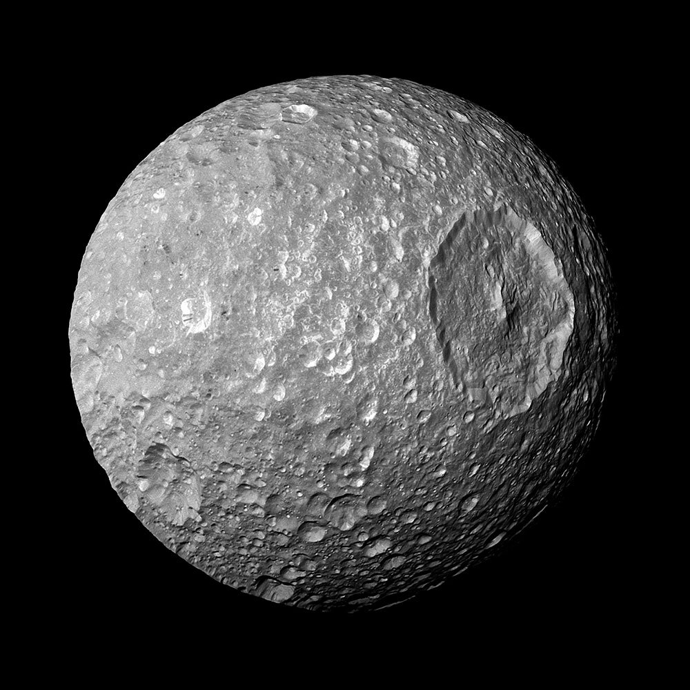 Mimas, one of Saturn's moons, showing the large Herschel Crater that makes the moon look like the Death Star from the movie Star Wars.