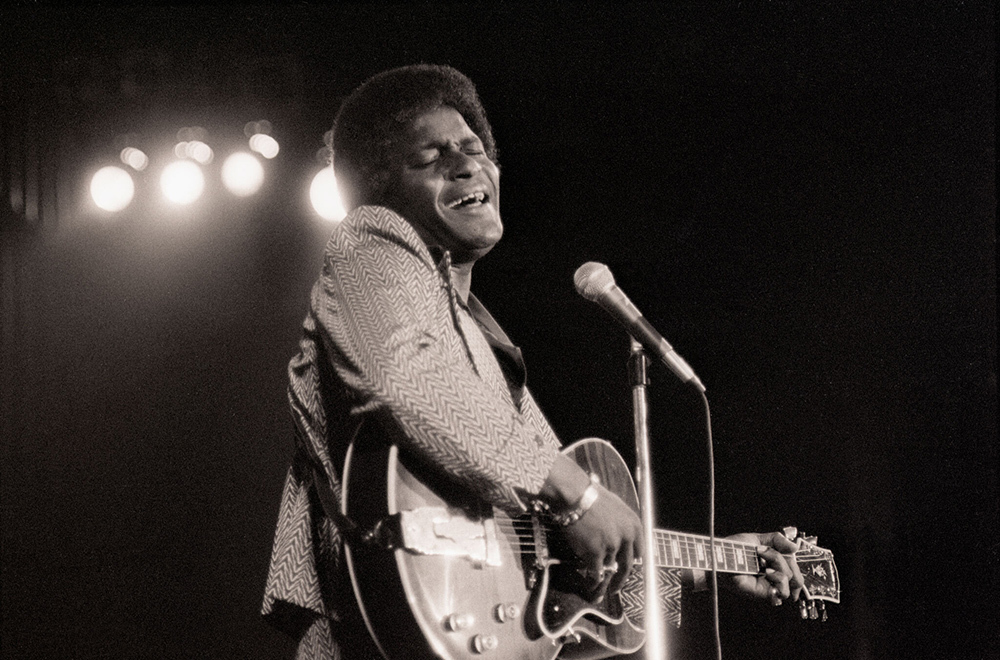 Country singer Charley Pride playing the guitar