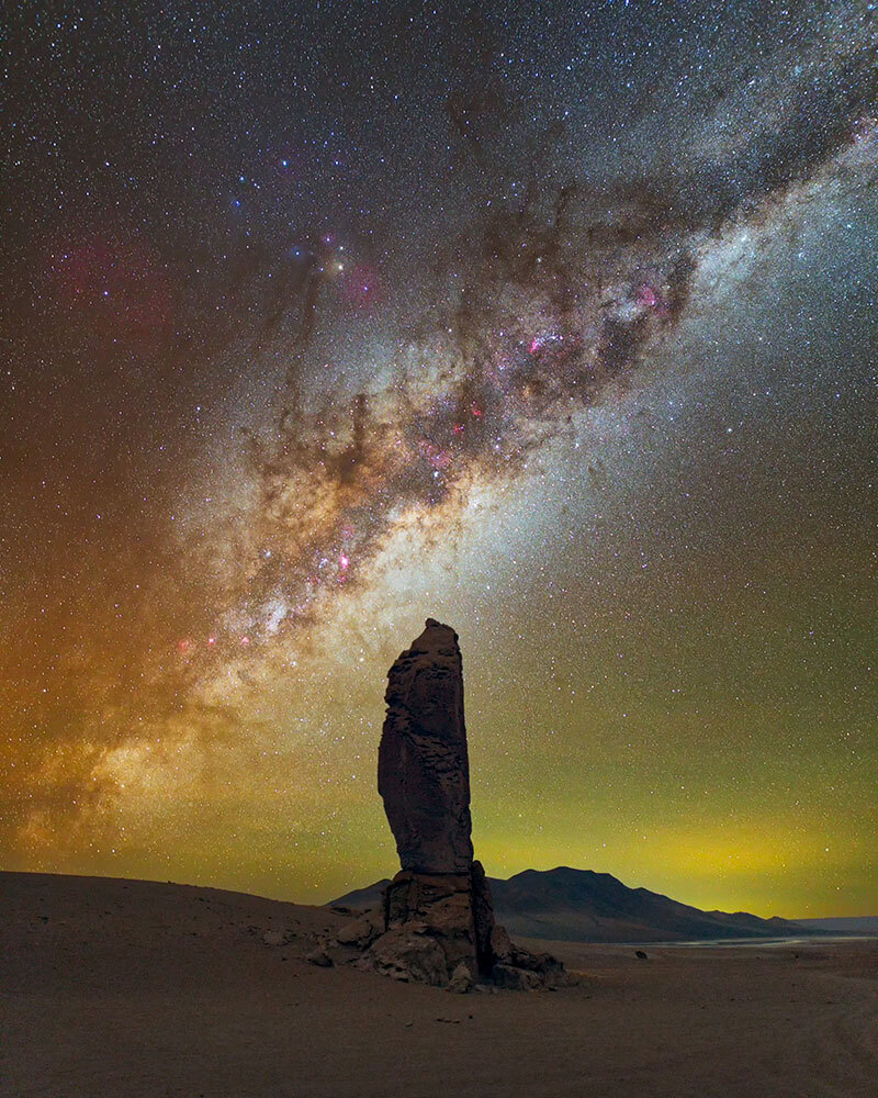 A picture of a column of rock with the Milky Way galaxy in the sky