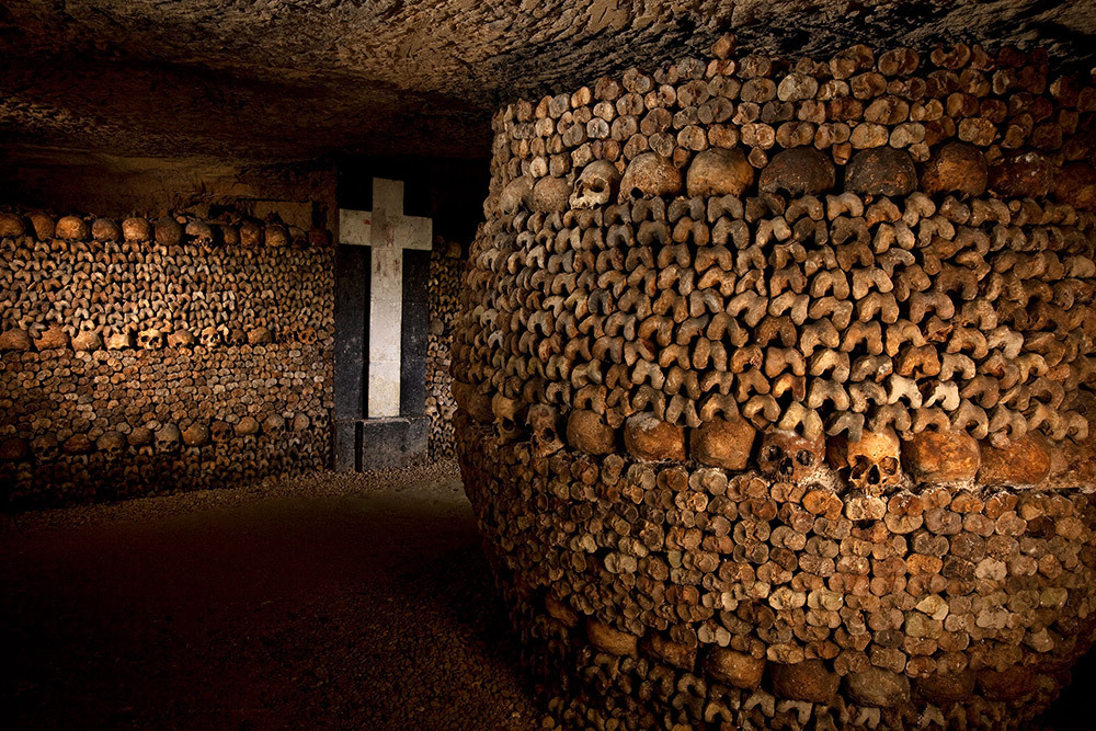 Neat stacks of skills, tibias, and femurs in the Paris catacombs