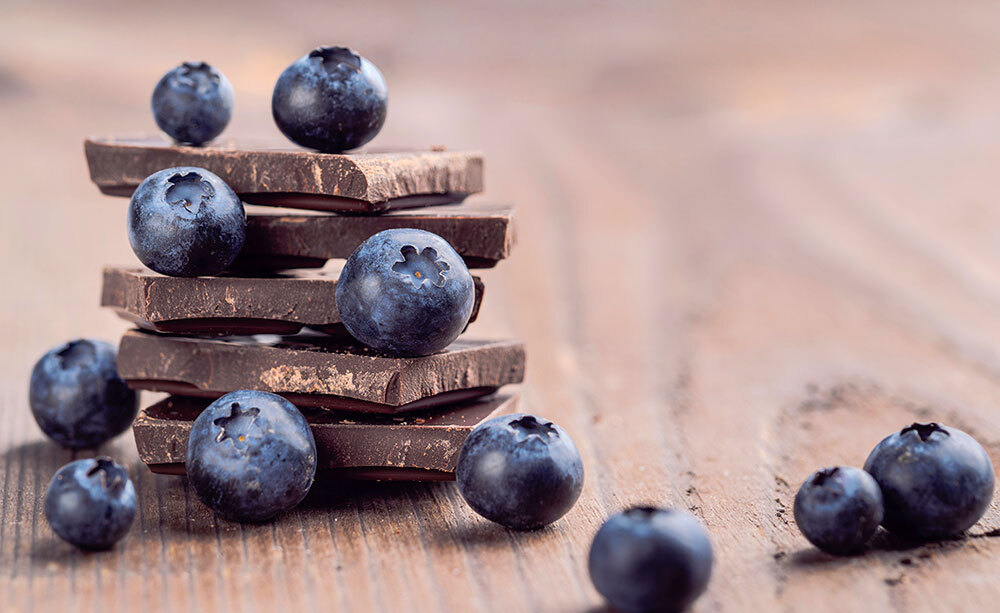 a stack of dark chocolate with blueberries