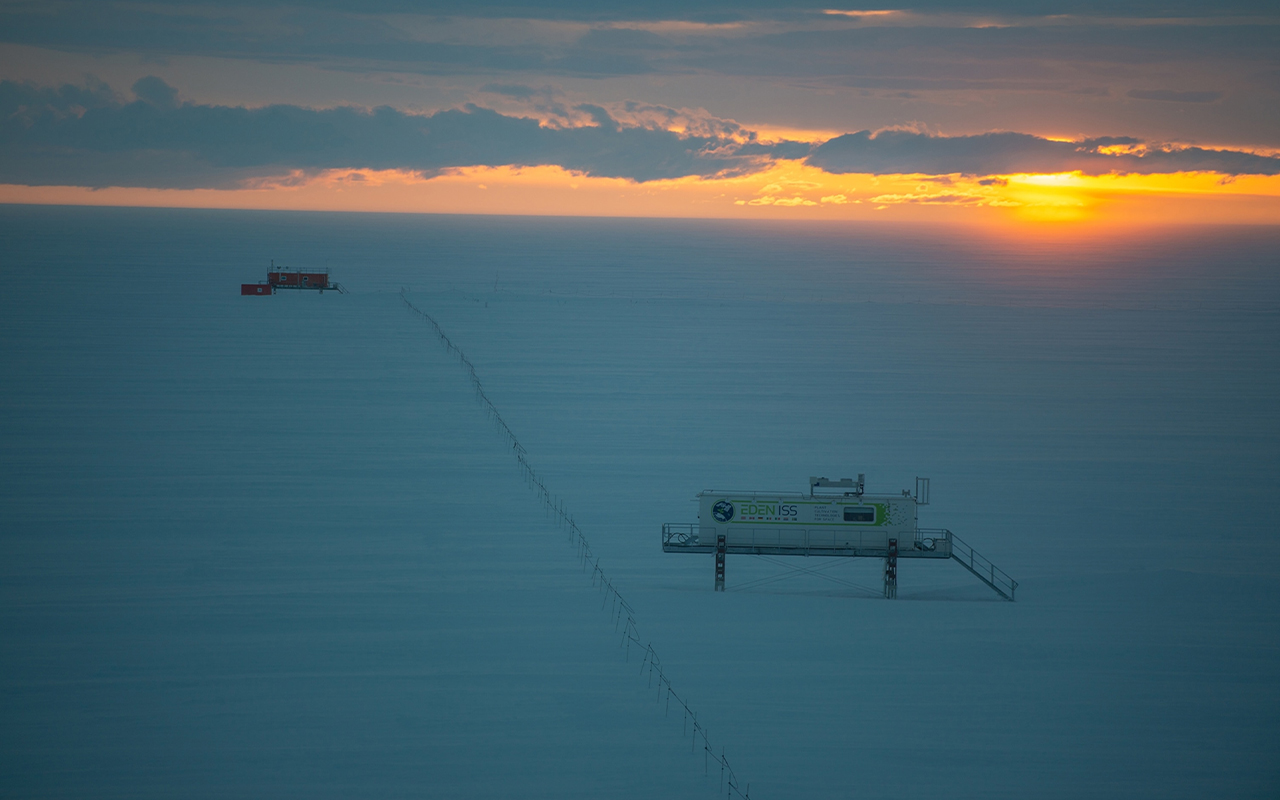 The sun sets over Neumayer Station's greenhouse and meteorological observatory.