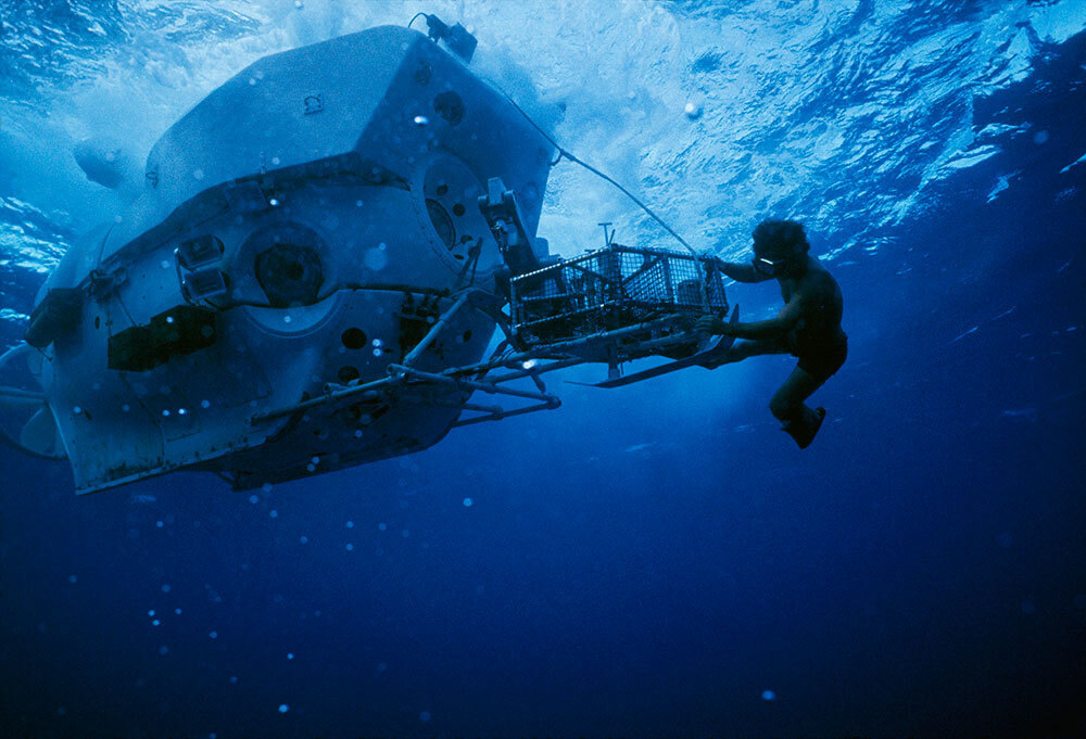 A diver works on a deep sea submersible near the surface of the ocean