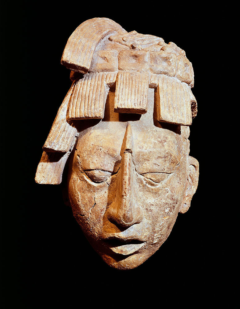 A stone sculpture of a Mayan warrior's head