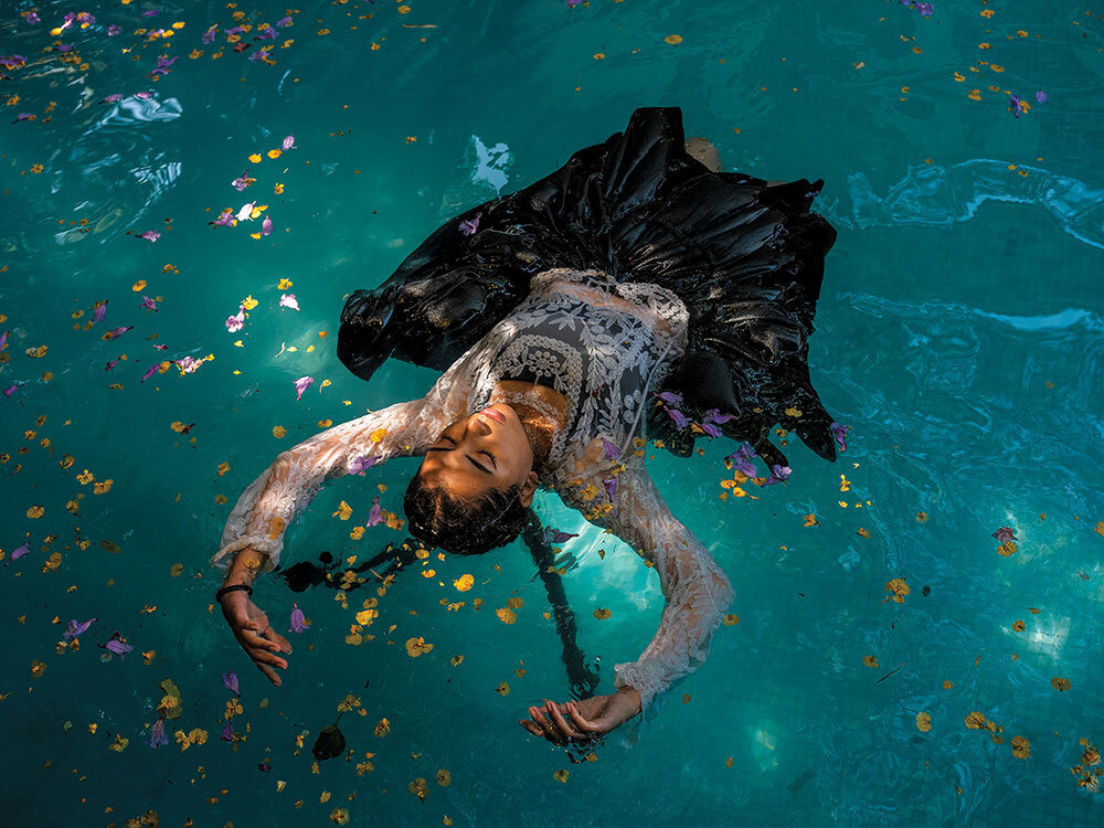 A picture of a woman floating in a pool with flowers