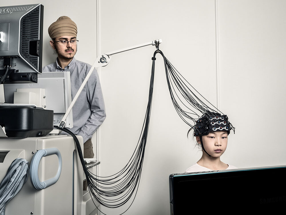 A picture of a person wearing a cap connected to many wires.