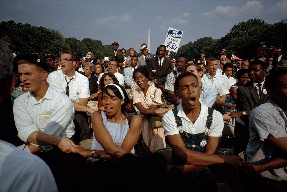 People join hands and chant at the Reflecting Pool on the National Mall in Washington, D.C.