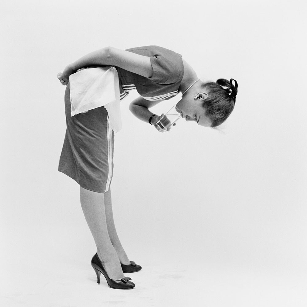 A woman drinks water upside down