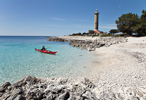 Pebblestone beach offers a resting spot for kayakers and a chance to visit Veli Rat lighthouse.