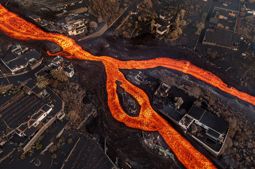 A river of lava flows through a neighborhood