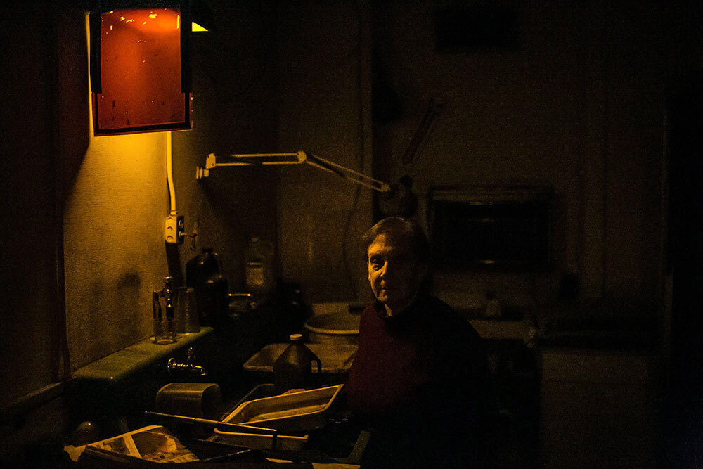 A portrait of an older woman in a darkroom